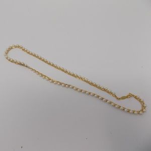Gold chain wrapped around faux white pearls